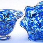 Two blue glass bowls sitting on top of a table.