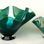 A pair of green glass bowls on top of a table.