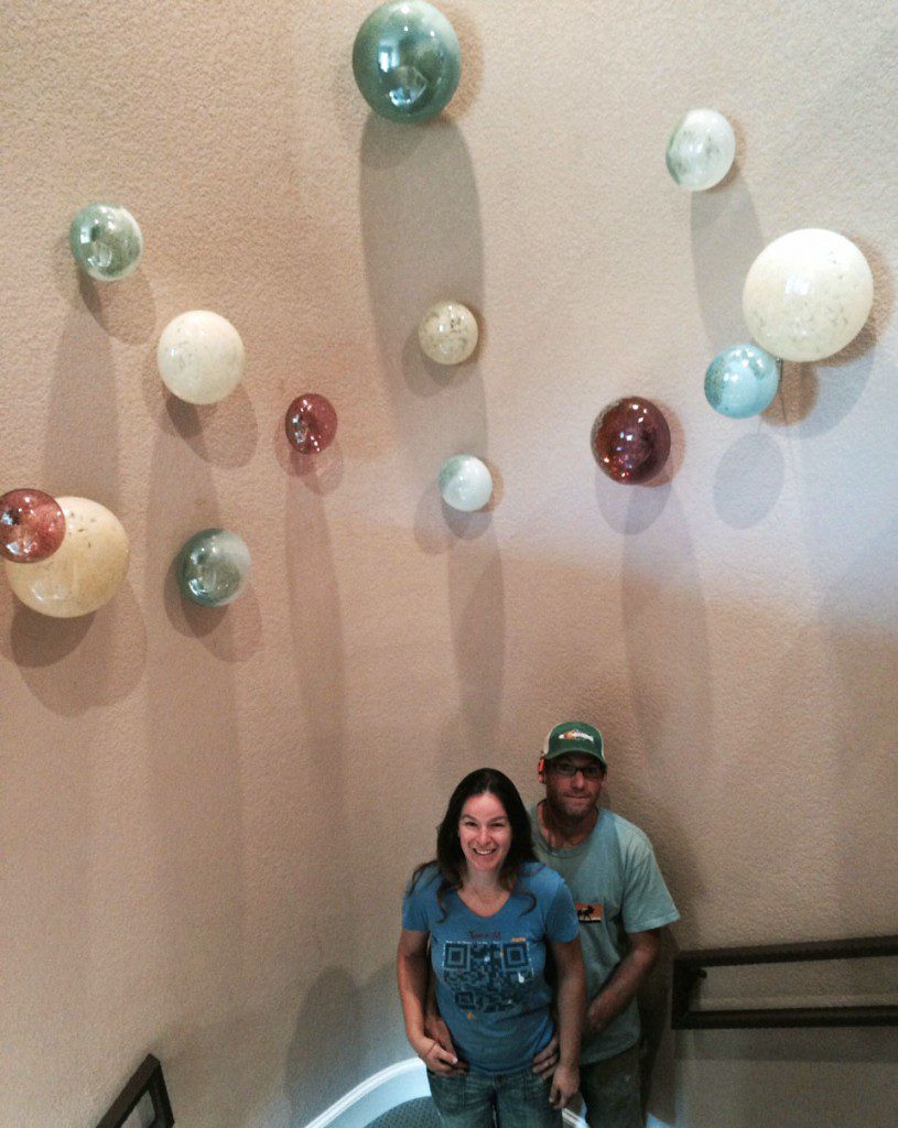 A man and woman standing in front of some plates.