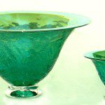Two green glass bowls sitting on top of a table.