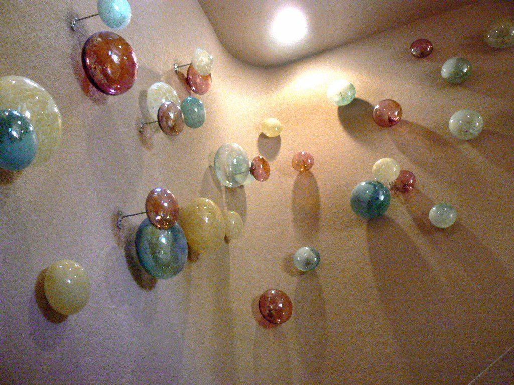 A wall with many glass balls hanging from it