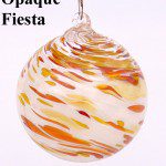 A white and orange glass ornament hanging from a hook.