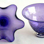 Two purple glass bowls sitting on top of a table.