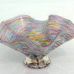 A glass bowl with colorful swirls on top of it.