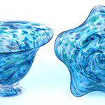 A blue glass bowl and vase with a white background