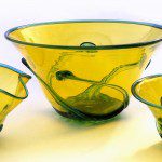 A yellow bowl and two smaller bowls with green swirls.