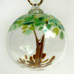 A glass ornament with a tree on it.