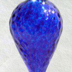 A blue glass vase with a pattern of bubbles.