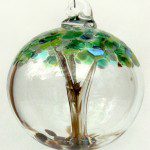 A glass ornament with a tree inside of it.