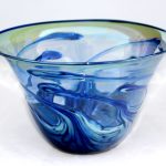A blue glass bowl with swirling design on it.