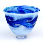 A blue and white bowl with swirls of glass