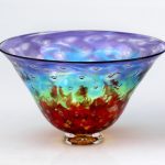 A glass bowl with red and blue colors on it.