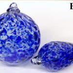 Two blue glass balls are sitting on a table.