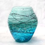 A blue glass vase with black lines on it