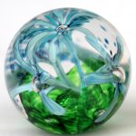 A glass ball with blue flowers inside of it.
