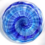 A blue glass bowl with a spiral design.