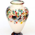 A white vase with colorful designs on it.