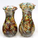 Two vases are shown side by side, one of which has a design on it.