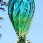 A glass vase with green and blue colors