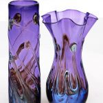 Two purple vases with a design on them.