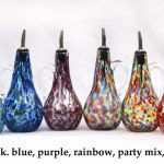 A group of six glass bottles with different colors.