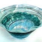 A bowl that is made of glass and has some design on it.
